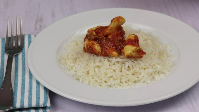 calamars, sauce tomate cuisin&eacute; et riz dans une assiette