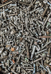 Many different small bolts, nuts, washers, grovers, studs and screws. Technical background. Industrial texture.