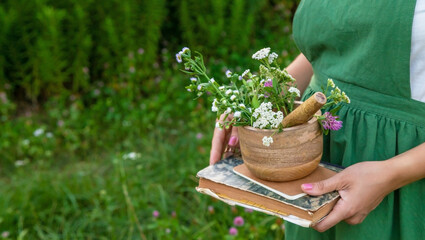 A woman collects medicinal herbs and makes herbal tincture.