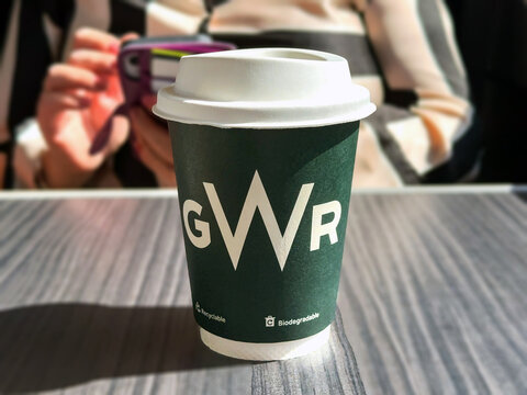 London, England, UK - 25 August 2023: Close up view of cup of coffee made of recyclable and biodegradable material in the first class section of a high speed train operated by Great Western Railway