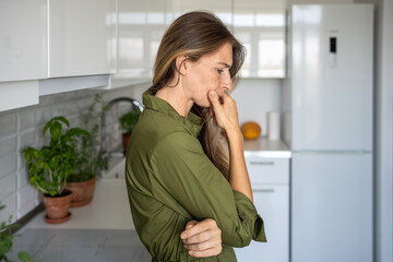 Depressive upset middle aged woman confused looking thinking about problems at home. Frustrated...