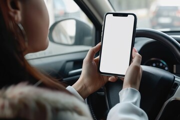 Woman sitting behind the wheel and showing phone with white screen mockup through window