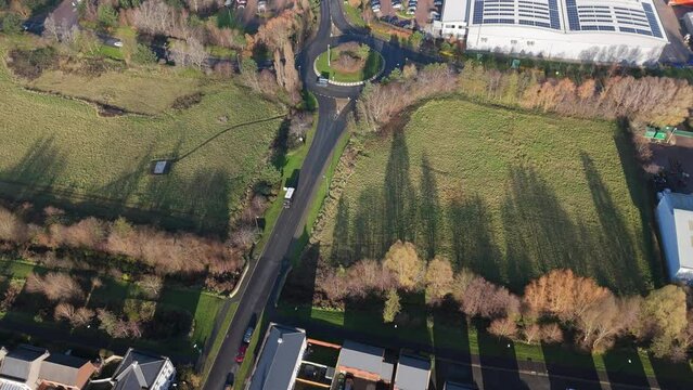 Aerial Advance Towards a Roundabout on a Rural Road with Industrial Vistas