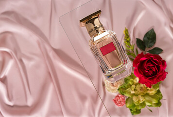 Mock up of elegant perfume bottle surrounded by flowers. Product mockup. Fragrance presentation