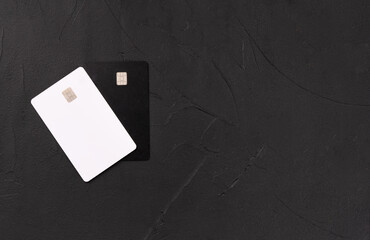 White and black credit cards on a blank dark background, top view. Copy space