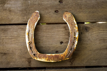 A rusty horseshoe screwed to a wooden wall