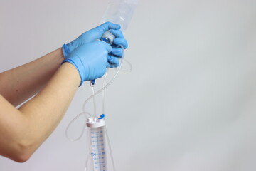 Measure volume infusion set beeing connected to the drug bag by a healthcare professional wearing gloves 