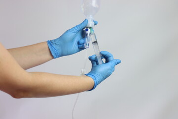 Healthcare care professional injecting drug in the saline solution to bee injected in an infusion...