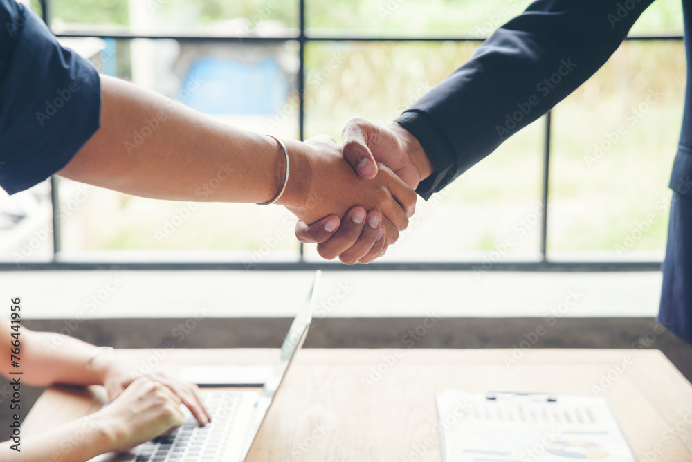 Wall mural two businessmen shake hands after success deal and finishing work with happy corporate employee and 