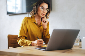 Professional businesswoman participating in an online meeting from her office