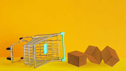 Fall in demand for goods. Market research, marketing. An overturned shopping cart with boxes of...