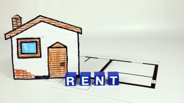 Single word RENT on wooden block, house rent taxes concept.