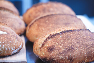 Fresh aromatic bread on a wooden table in a bread store or bakery. Nutrition concept