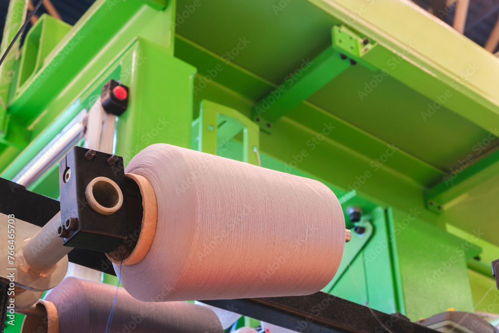 Aufkleber three orange spools of thread are on a machine