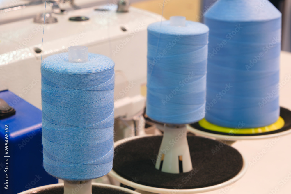 Aufkleber three blue spools of thread are on a machine