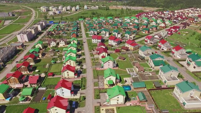 Aerial drone shot of a Small Town with colorful houses, a good road, green trees and yards. Satellite town Lesnaya Polyana nearby Kemerovo, Siberia.
