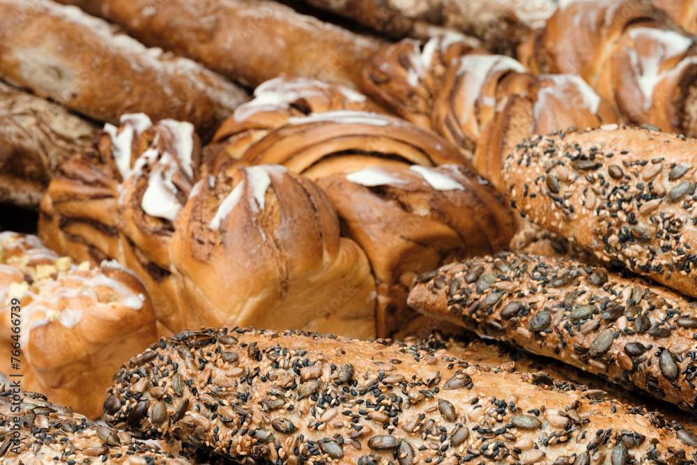 Poster A variety of breads and pastries are displayed, including some with nuts and seeds. Concept of abundance and variety, with a focus on the different types of bread and pastries available
