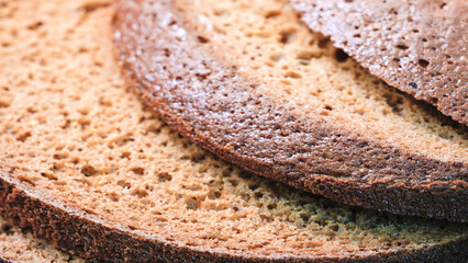 A close up of a slice of bread with a brown crust. The bread is cut into slices and stacked on top of each other