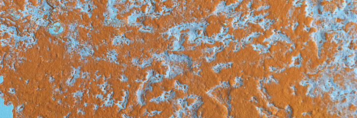 Panoramic image. Orange plaster peeling off an old wall. Old dirty peeling plaster wall. Texture, pattern, background