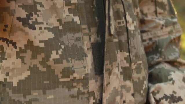 Female servicewoman brave soldier dressed in the camouflage military uniform, zipping up fastens closing the lock, symbol of independence. Armed Forces of Ukraine. Woman serving in ukrainian army 
