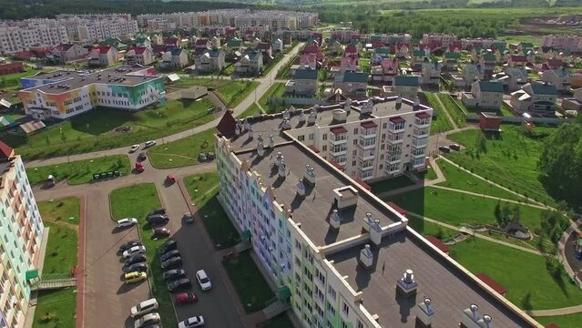 Aerial drone shot of a Small Town with colorful houses, a good road, green trees and yards. Satellite town Lesnaya Polyana nearby Kemerovo, Siberia.