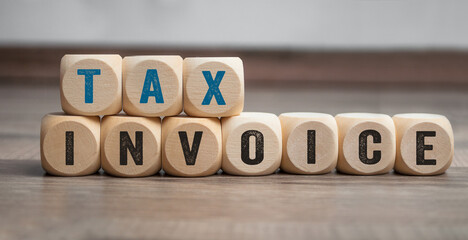 Cubes, dice or blocks with tax invoice on wooden background