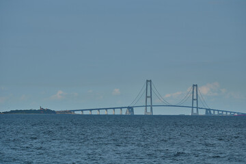 Fototapeta na wymiar great Storebelt suspension bridge connecting Denmarks islands across the baltic sea on a hazy sunny day.