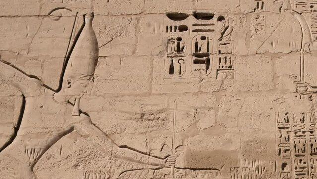 Ancient Egyptian hieroglyphs and bas-reliefs close-up in Temple of Medinet Habu. Egypt, Luxor. The Mortuary Temple of Ramesses III at Medinet Habu located in the West Bank of Luxor in Egypt.