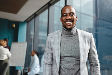 Happy african businessman smiling in office boardroom
