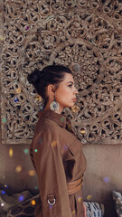 beautiful woman in profile against the background of a wooden carved composition