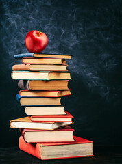 Close-up of a stack of books with a red apple on top