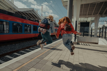 Two friends jumping on a train station