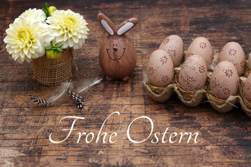 Grußkarte Frohe Ostern: Osterhase und Ostereier in einer Eierschachtel mit dem Ostergruß Frohe Ostern.
