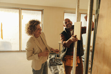Happy home renovation team: Collaborative interior designer and contractor improving a home's interior - 766486349