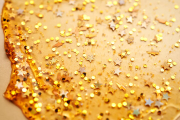 Cosmetic gel with glitter on a beige background.
