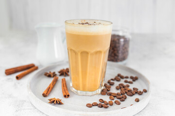 Coffee latte in glass with cinnamon, spices and roasted coffee beans. Creamy coffee with milk....