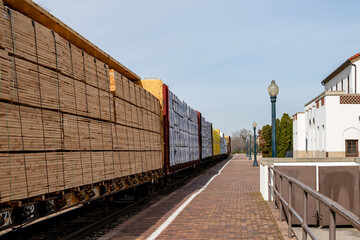 Train travels past a depot loaded with cargo