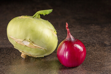 Vibrant still life composition with red onion and kohlrabi on dark background