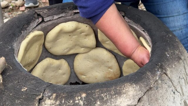 Woman Baking Traditional Tunisian Bread (Tabouna) in a Terracota Oven (Tabouna)