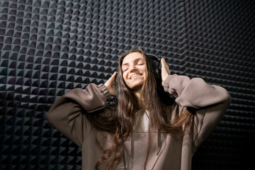 Smiling Woman Enjoying Music in a Professional Studio With Acoustic Foam Walls - 766503189