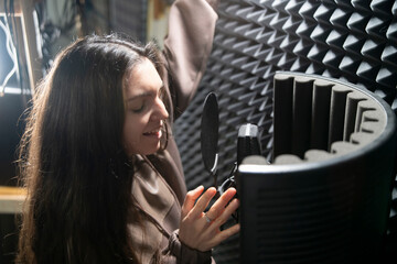 Young Female Artist Recording a New Song in a Soundproof Music Studio - 766503330