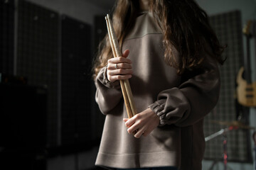 Drummer hands Holding Drumsticks While Standing in a Rehearsal Studio - 766503741