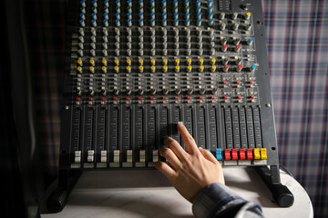Sound Engineer Adjusting Faders on a Mixing Console During Studio Session - 766503903