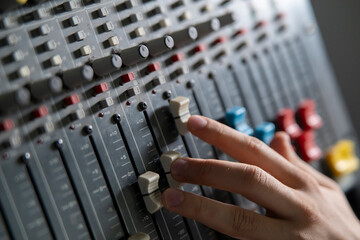 Sound Engineer Adjusting Faders on a Mixing Console During Studio Session - 766503967