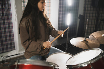 Smiling Woman Playing Drums Enthusiastically in a Music Studio Setting - 766505581