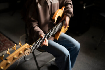 Young Musician Playing electric Guitar in a Studio Setting During a Rehearsal, playing accord