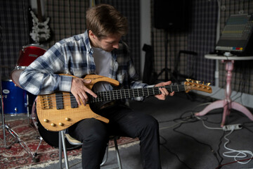 Young Musician Playing electric Guitar in a Studio Setting During a Rehearsal, playing accord - 766506584