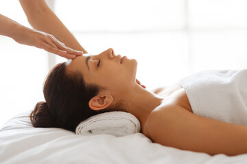 Fototapeta na wymiar Side view of therapist making head massage for lady indoors