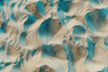 The image is of a beach with a blue and white sand. The blue sand is scattered throughout the beach, creating a unique and interesting texture
