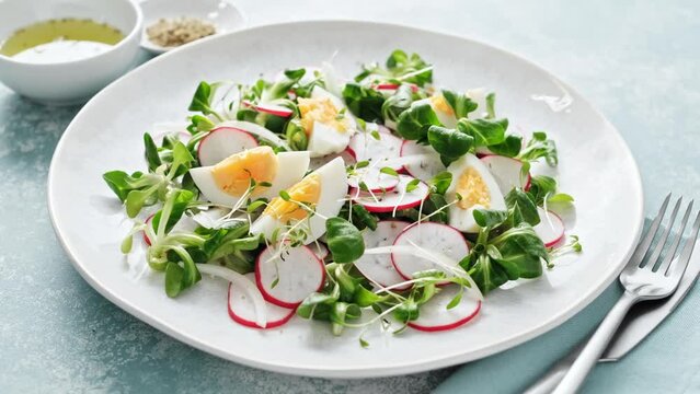 Spring radish and eggs salad. Fresh Easter salad with boiled eggs, cornsalad lettuce and radish. Stock footage video 4k